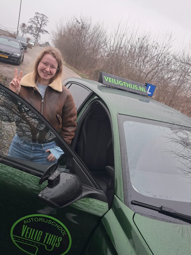 Geslaagde leerling met haar rijbewijs bij Veilig Thijs