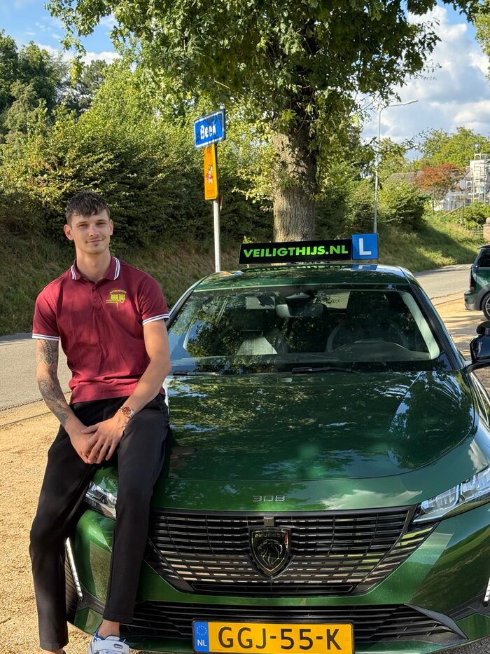 Thijs Pinkaarts bij de lesauto van Autorijschool Veilig Thijs in Beek