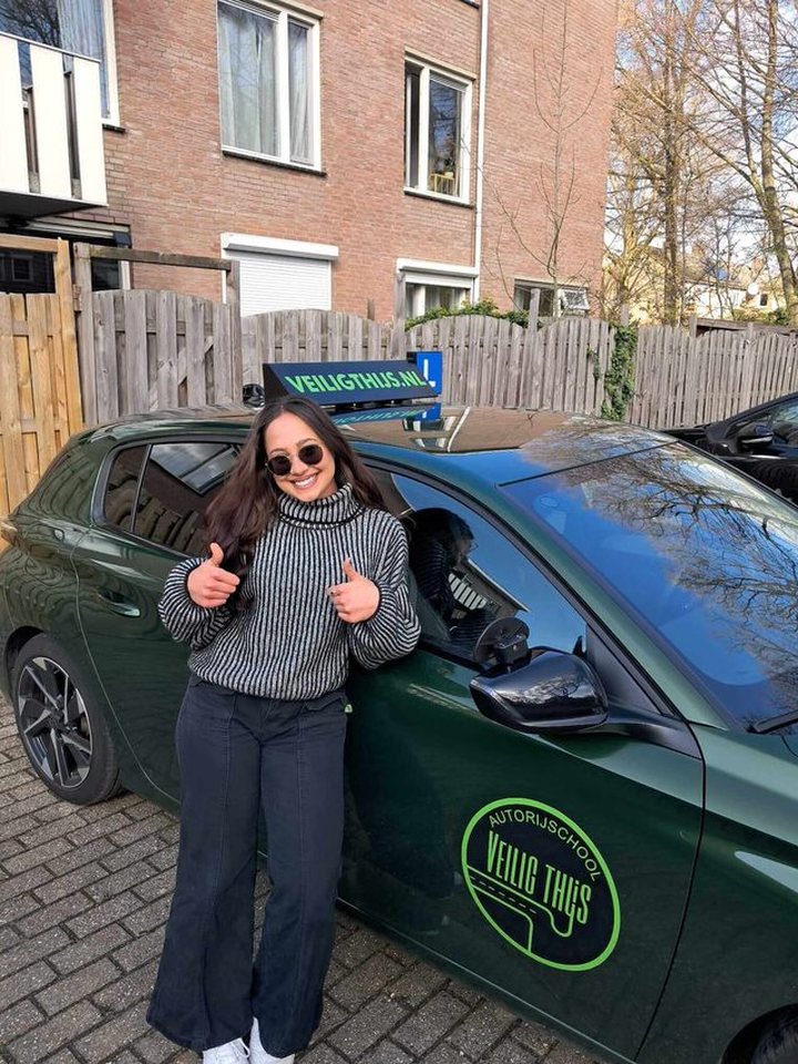 Geslaagde leerling naast de lesauto van Autorijschool Veilig Thijs