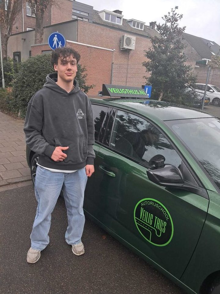 Geslaagde leerling naast de lesauto van Autorijschool Veilig Thijs