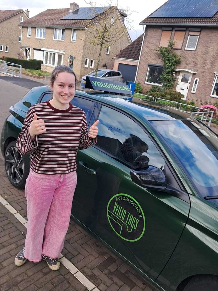 Geslaagde leerling naast de lesauto van Autorijschool Veilig Thijs