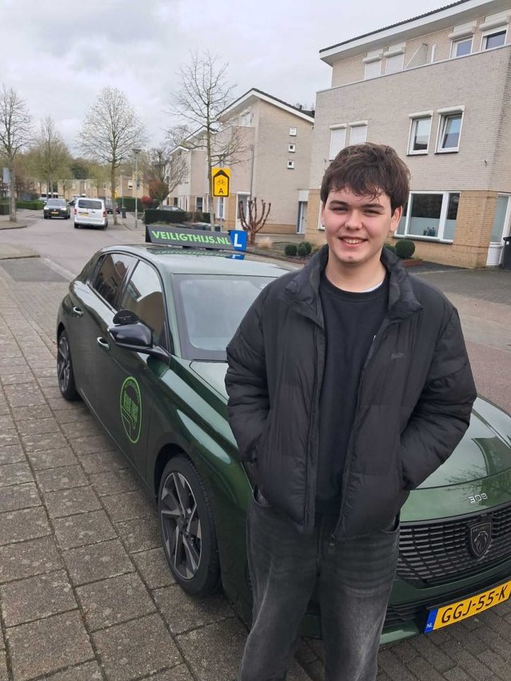Geslaagde leerling naast de lesauto van Autorijschool Veilig Thijs